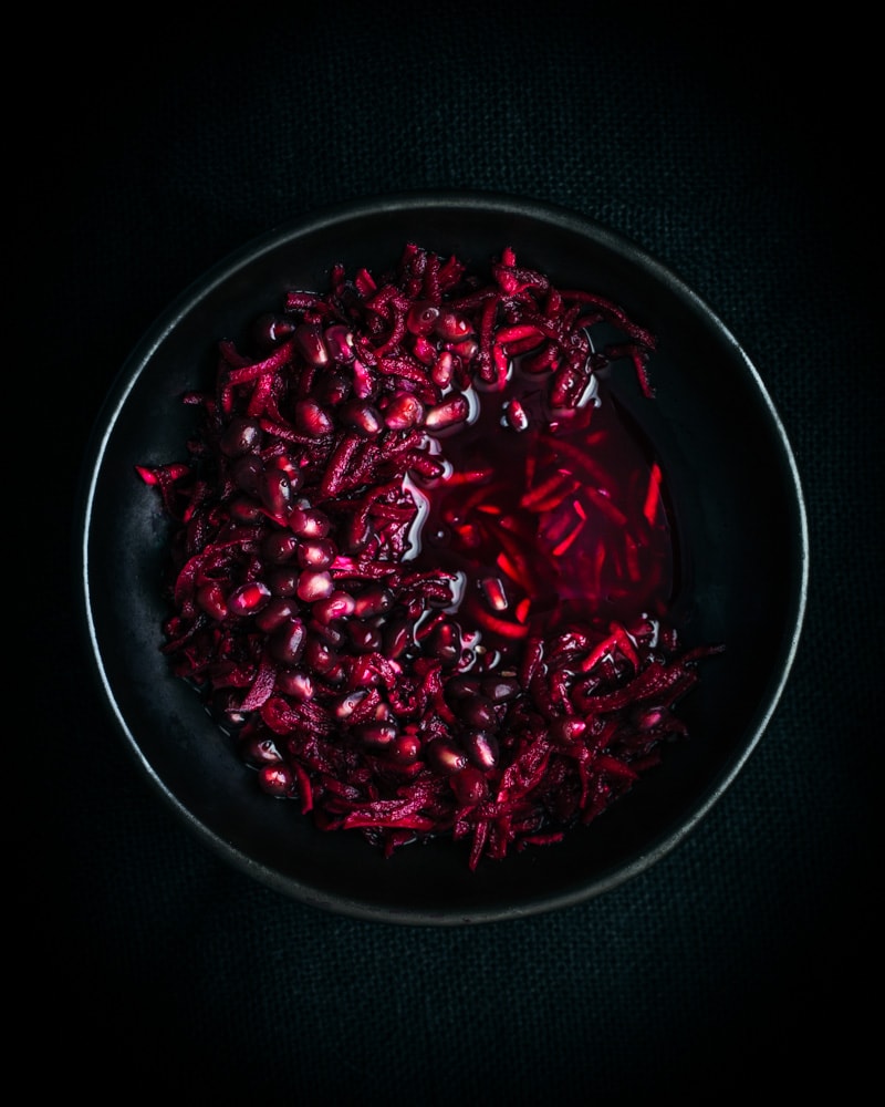 Shredded beets floating in black bowl