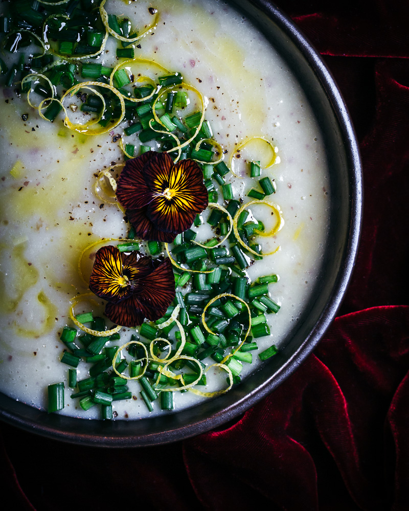 bowl of potato leek soup with red violas