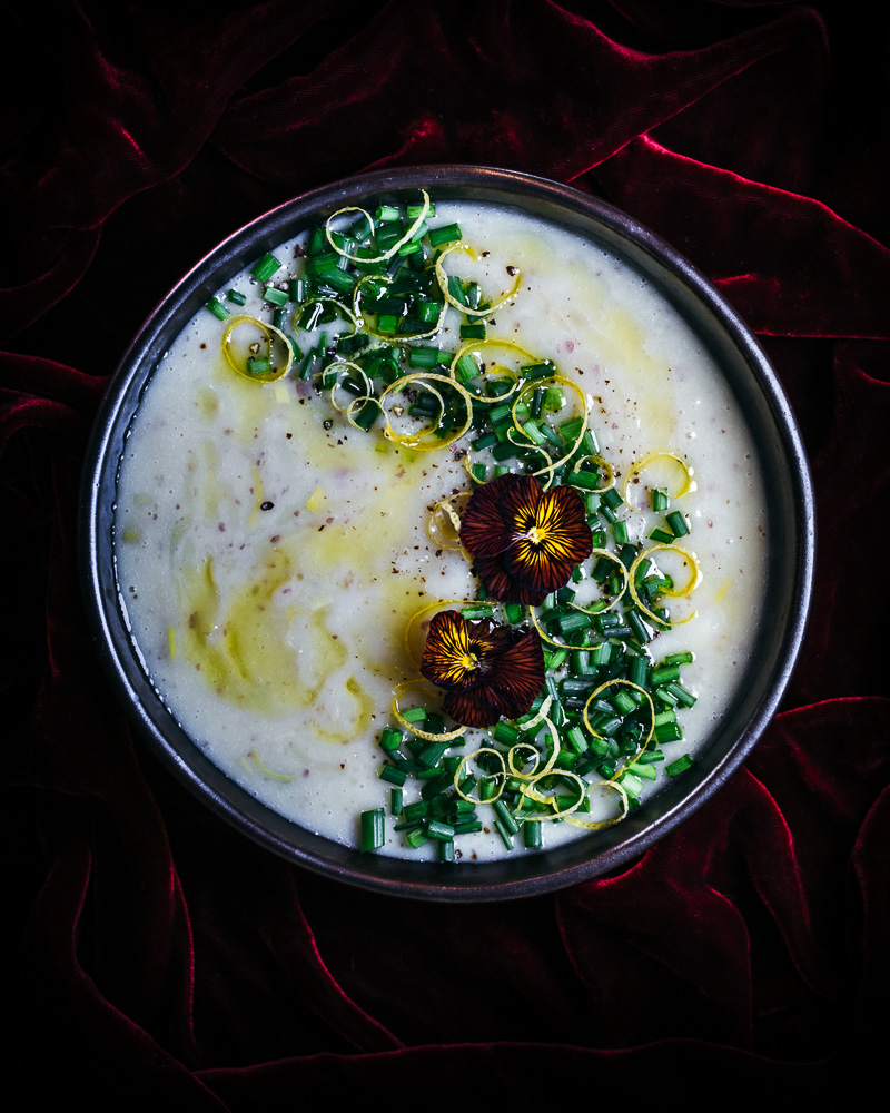 Bowl of potato leek soup with red violas